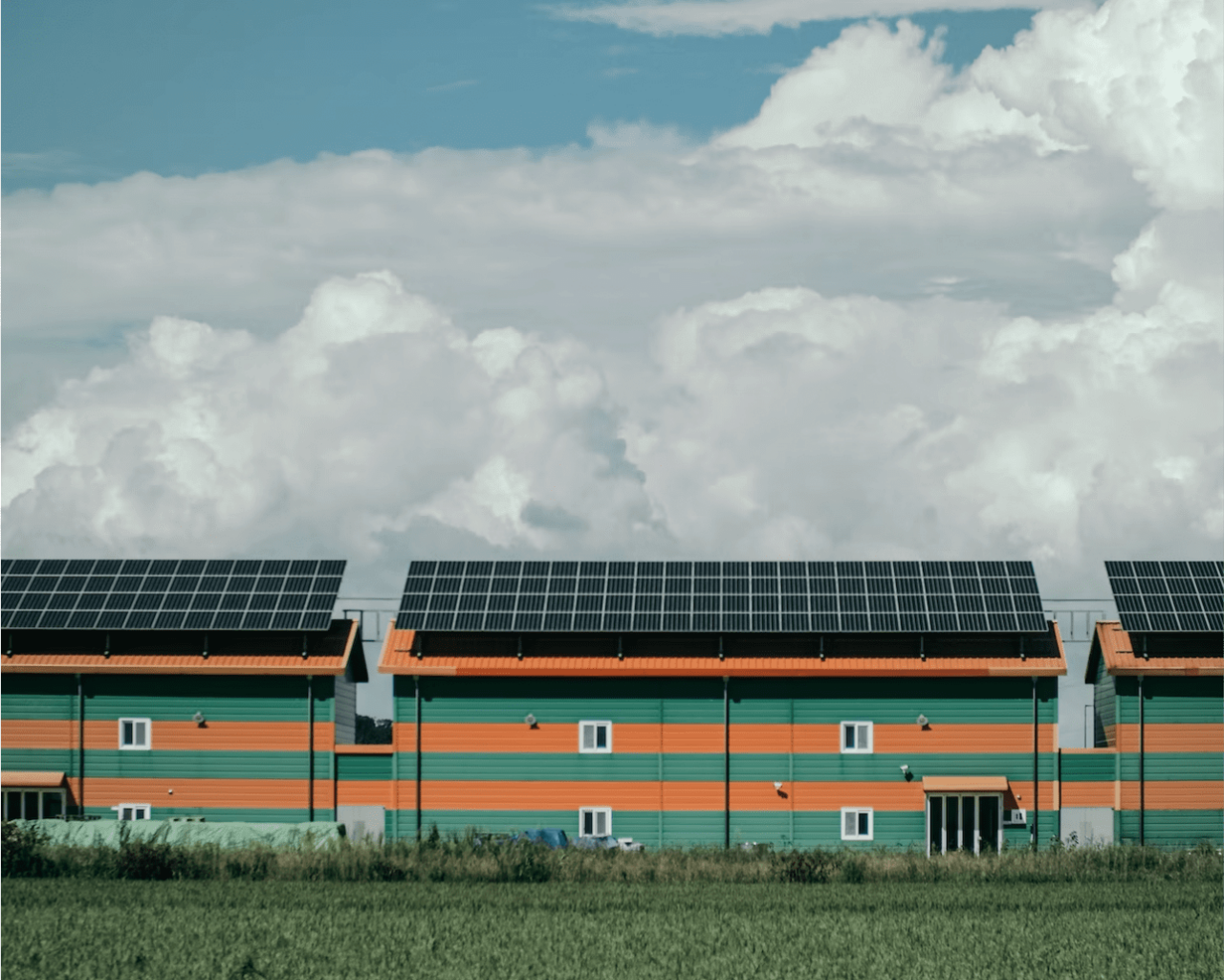 Commercial buildings with green and orange stripes with solar panels on their roof tops